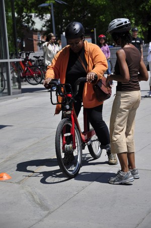 Elan Dawkins (left) gets some tips from instructor Marya McQuirter (right) before riding downhill on a Captial Bikeshare bike.