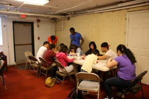 Youth participants and volunteers help each other with homework after school at the Vietnamese American Community Service Center.