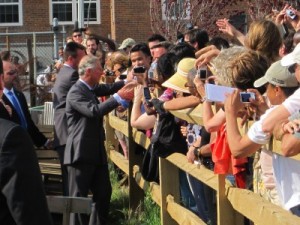 Prince Charles took time out of his farm tour to visit with community members standing outside the wooden fence.